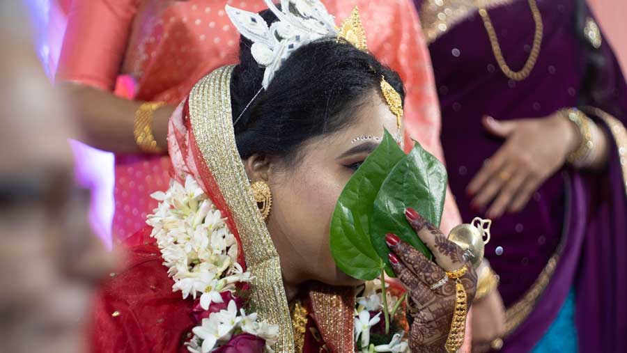  The bride covers her face with betel leaves before being taken to the ‘chadna tola’
