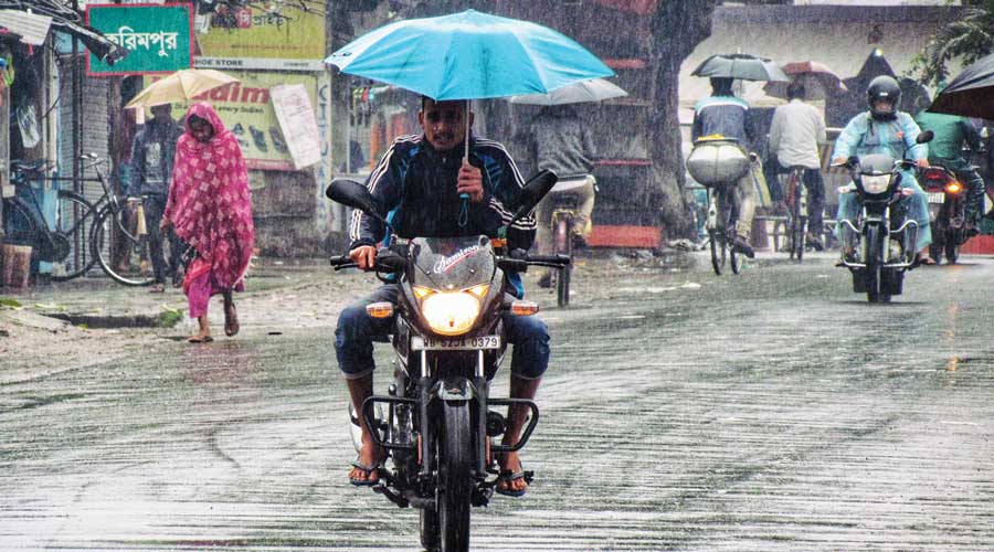A biker during rain at Karimpur in Nadia district on Monday. 