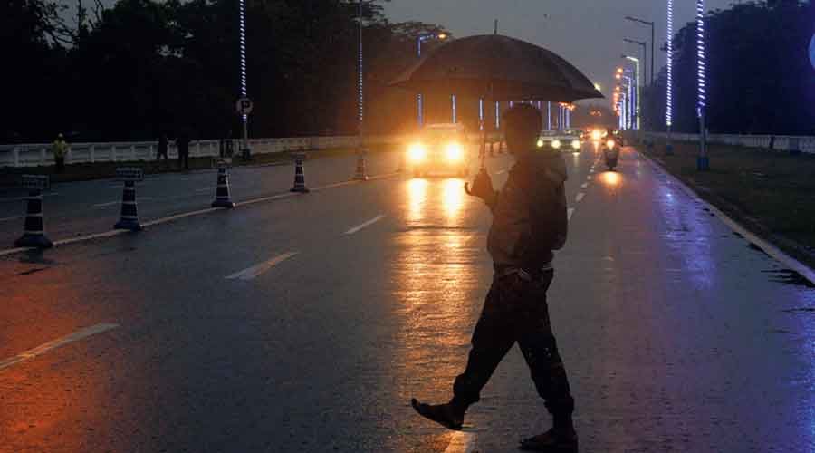 A pedestrian amid rain on Red Road Kolkata on Monday evening. 