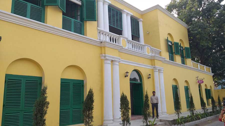 The colonial building housing the tavern is painted bright yellow and green, and has a double column façade
