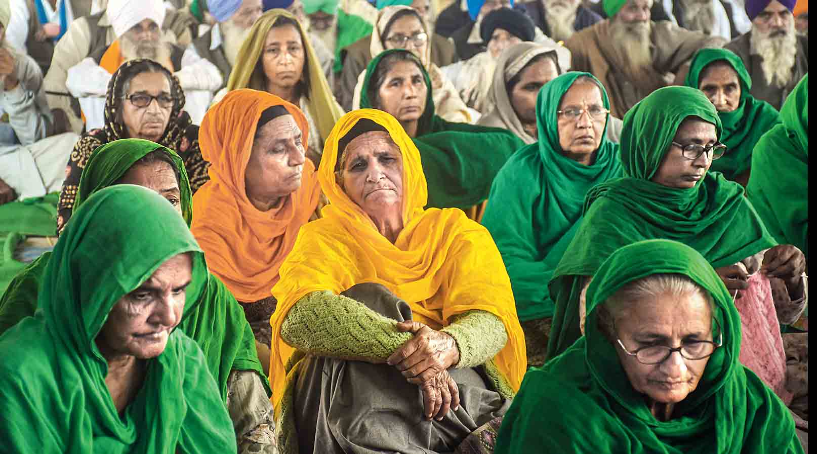 Farmers listen to a speaker at the Singhu border protest site on Wednesday