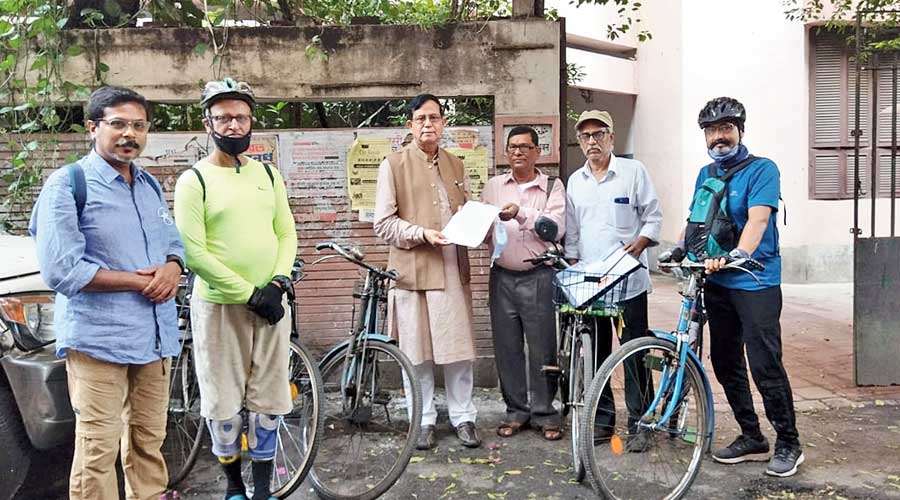 A group of cyclists hands a letter to Md Salim of the CPM