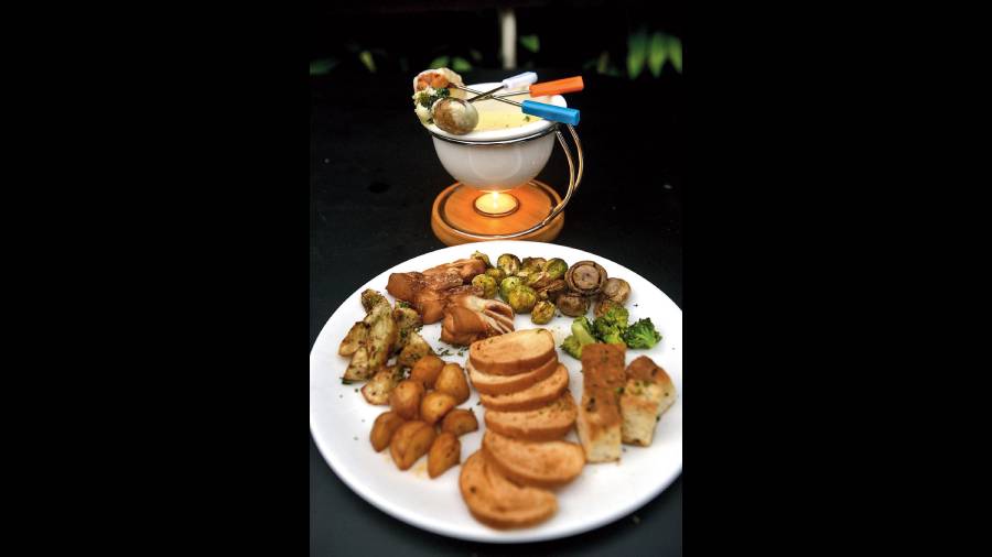Classic Fondue: The rich flavours of the fondue is accompanied by herbed baby potatoes, garlicky sweet potatoes, broccoli, mushroom, brussel sprouts, toasted focaccia, tomato bread and melba in this wholesome platter. Rs 1,475