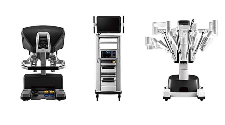 A fourth-generation Da Vinci surgical system comprising (left) the surgeon’s console, (centre) the vision cart and  the robotic arms.