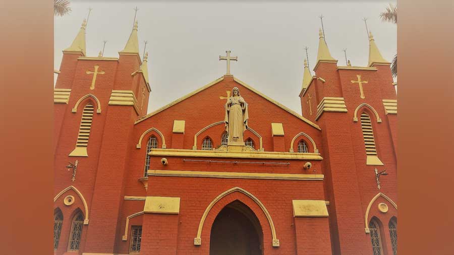 The red-brick church building has two castle-like towers, each crowned with four pinnacles