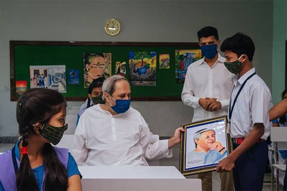 Jasawant Jani, a student of Class X, gifts a portrait of Naveen Patnaik to the Odisha chief minister.