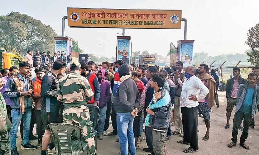 A BSF official (in camouflage) speaks to agitating Indian drivers at the zero point of the India-Bangladesh border near Petrapole . 