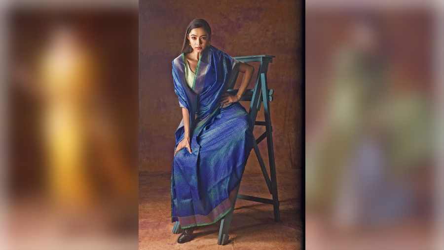 On Diti, an ombre blue sari inspired by the colours of the Pangong Tso lake that mesmerises with its natural gradient effect. The colourful Tanchoi woven Benarasi along with geometric patterns add a contemporary touch to this simple and elegant look.