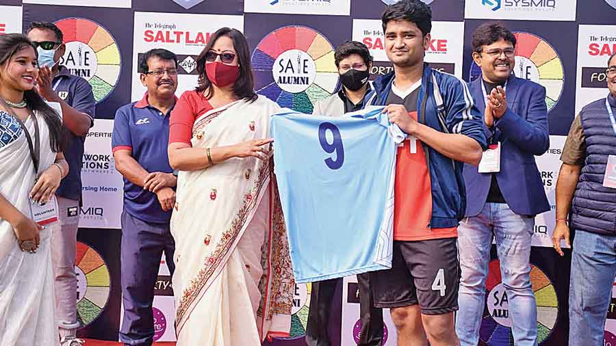 SAIE Teacher Rupa Dasgupta hands over the jerseys to the winning captain Rashtri Saha. 