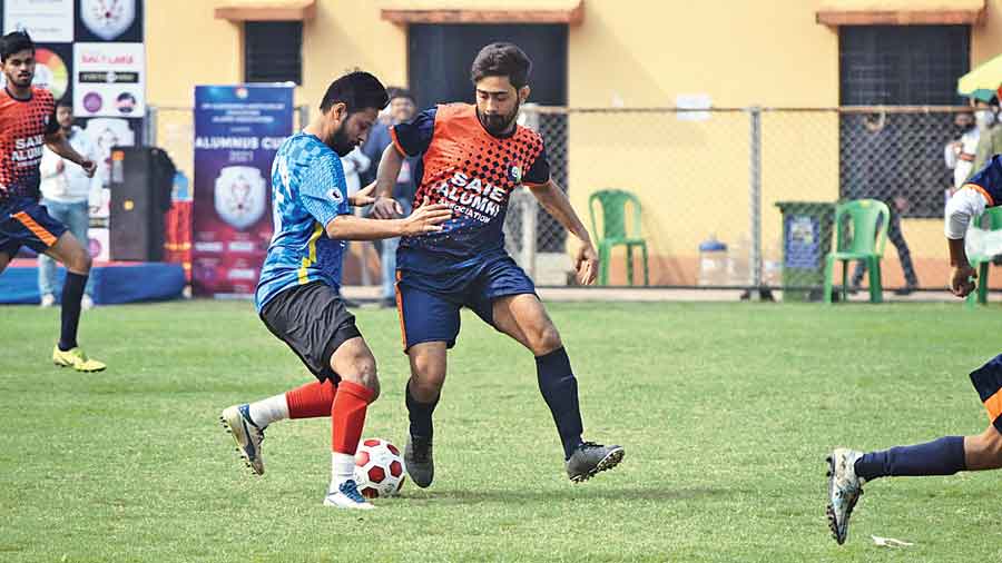 Rudradeep De of SAIE Alumni Association battles for the ball against a Bhavan’s alumni team player