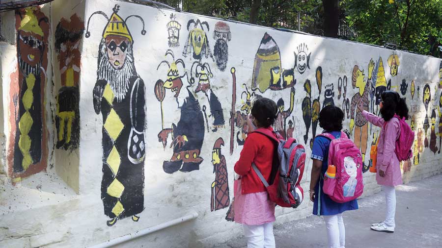 Students look at the graffiti outside Patha Bhavan school in Palm Avenue.