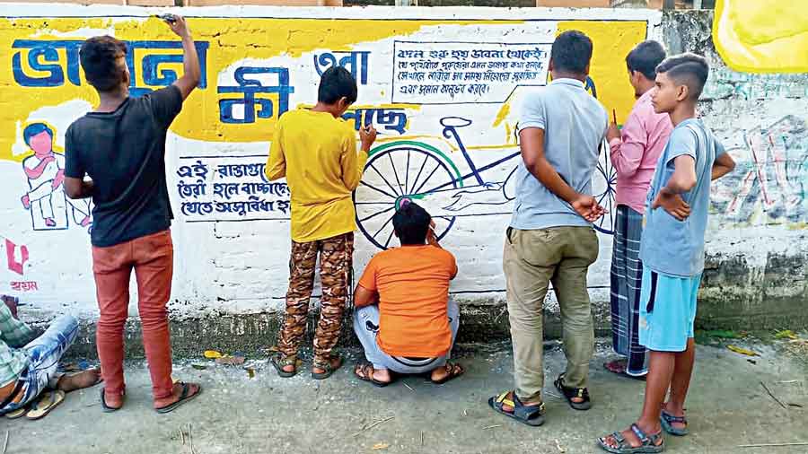 The group paints a wall in Diamond Harbour.
