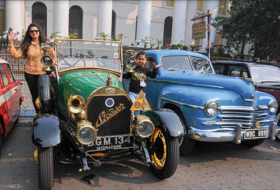 VINTAGE CHARM: A woman and a child pose for a photograph at the Goodbye 2021 Breakfast Meet organised by The Eastern India Motoring Group on Sunday, December 12. The Kolkata-based club held a car rally with 60 vintage and classic beauties from Town Hall to Eco Park in New Town