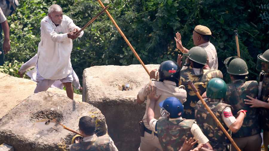 A farmer clashes with police personnel at the Delhi-UP border during the agitation