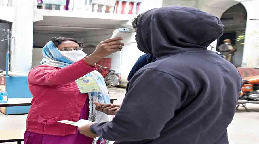 A voter’s body temperature being measured at a polling booth in central Calcutta.