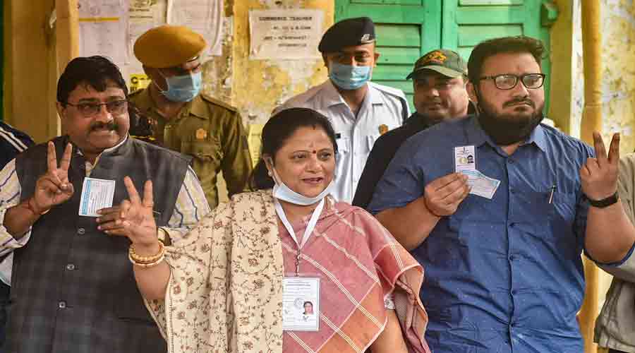 Kajari Banerjee (C), Chief Minister Mamata Banerjee's sister-in-law and TMC candidate, flashes victory sign after casting her vote , in Kolkata, on Sunday.
