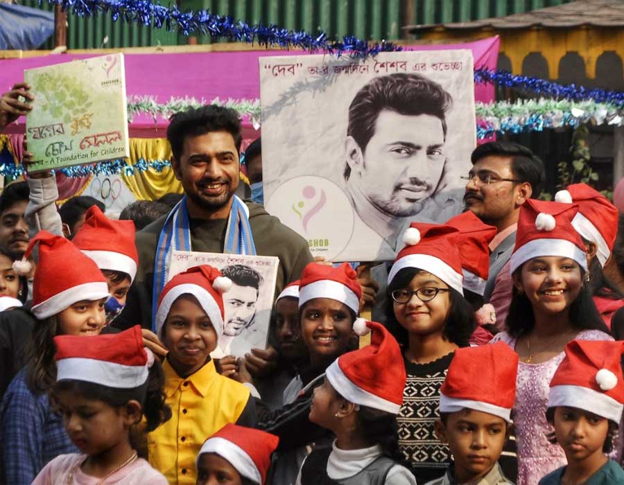 PRE-BIRTHDAY BASH: Actor-turned-MP Dev poses for a photograph with children at Press Club Kolkata on Friday, December 24, on the eve of his birthday