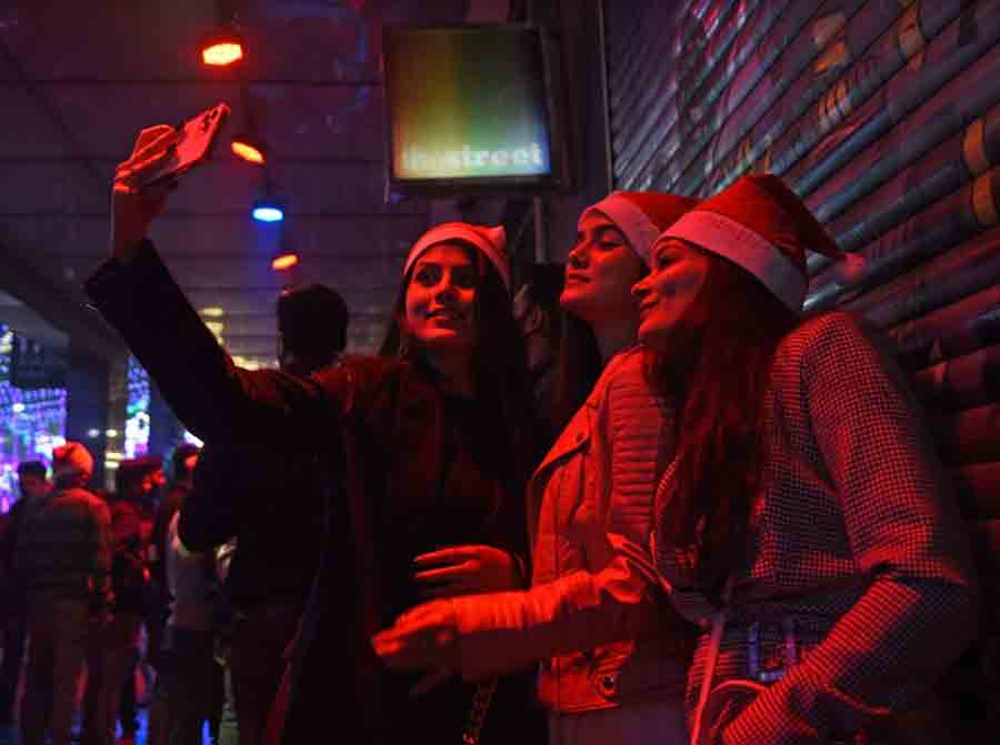 MIDNIGHT FUN: Three Christmas revellers take a selfie in front of The Park hotel in the wee hours of Saturday, December 25