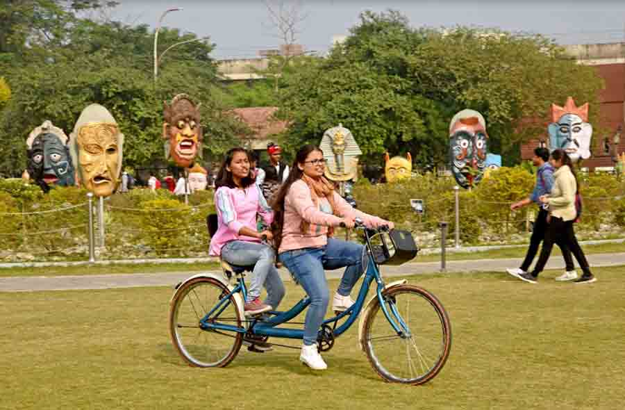 Two nattily dressed youngsters enjoy a ride on a tandem bicycle at the Eco Park in New Town on Saturday