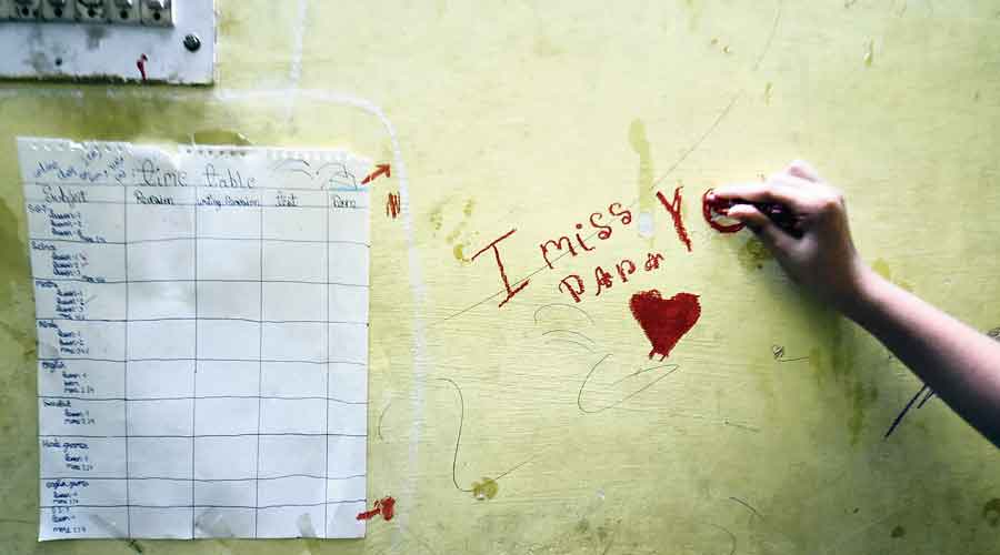 A girl who lost her father to Covid scribbles  “I miss you papa” on a wall in New Delhi on  May 9, 2021.