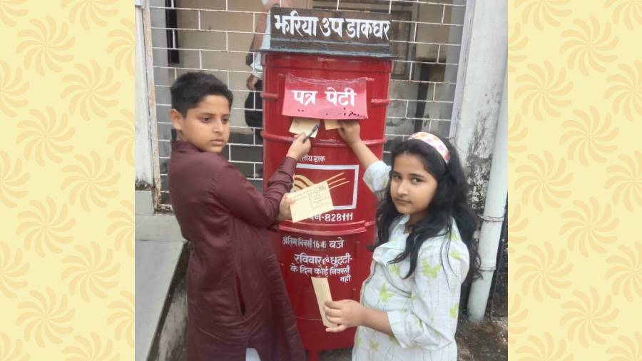 Children dropping postcards in a letter box to flag off the postcard campaign, on Friday.