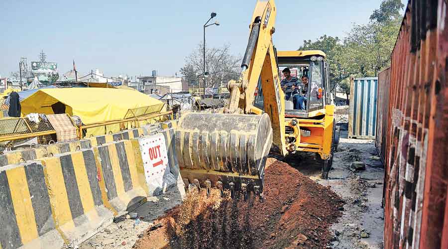 An earthmover deployed to dig a trench at the  Singhu border on Sunday