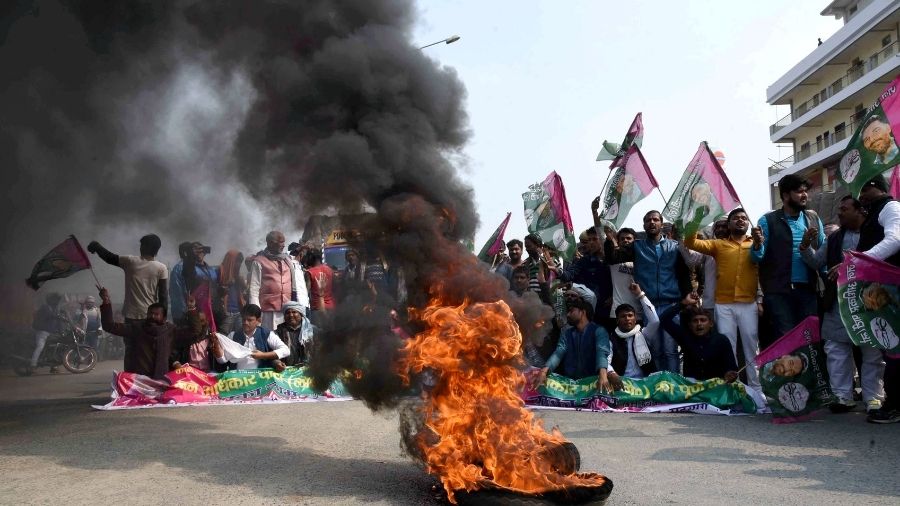 Jan Adhikar Party workers burn a tyre, block NH-30 during the 'chakka jam' protest in Patna, on Saturday.