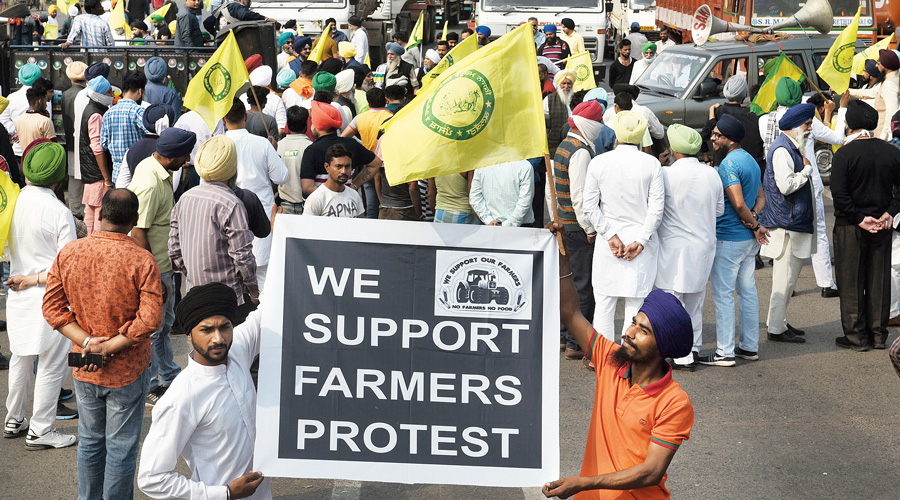 Demonstrators hold poster in solidarity with the farmers’ protest.