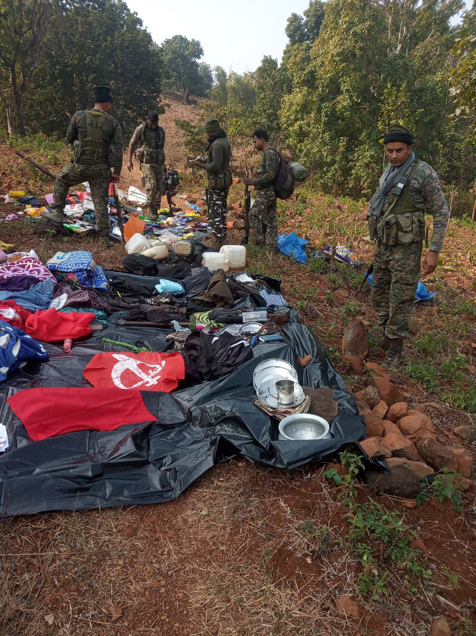 Paramilitary forces look at materials, including ammunition and IEDs, left by the naxals near the encounter spot in West Singhbhum on Sunday.