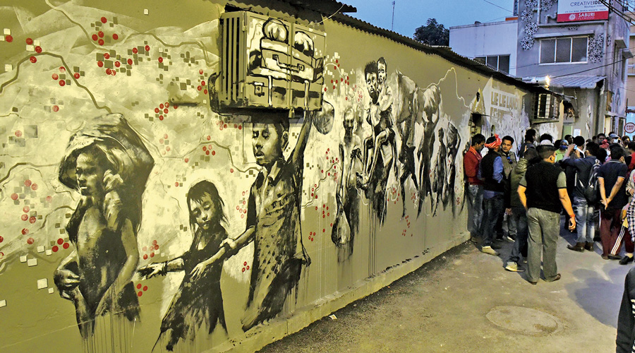 A wall painting shows migrant workers walking home during the lockdown.