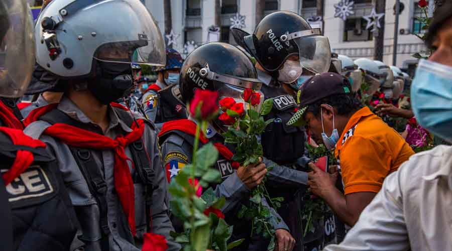Demonstrators protesting the military coup present roses to police in Yangon