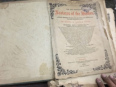Guin flips the pages of The Ten Principal Avataras of the Hindus with A Short History Of Each Incarnation And Directions For The Representation Of The Murtis As Tableaux Vivants, by Sourindro Mohun Tagore (1880). Every other page is a full page litho print of an avatar by Kristohury Das.
