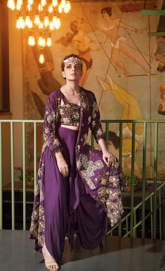 If you love a bit of drama, accessorise chunky, like we did with this headband designed with Keshi pearls, uncut diamonds and Bikaneri meena work from Madanji Meghraj. A perfect complement to the aubergine set with an embroidered bustier, draped pants and a jacket with asymmetric embroidery.