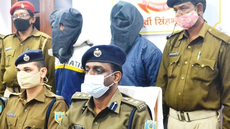 Senior SP, M Tamil Vanan (in blue mask) with the two arrested persons standing behind at the police station on Tuesday in Jamshedpur.