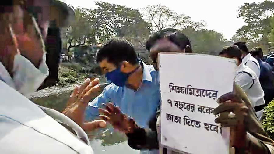 A para-teacher holds a placard