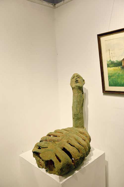 Two artworks at the exhibition. A terracotta sculpture, made by Ram Kumar Manna, shows a farmer with a skeletal  torso.