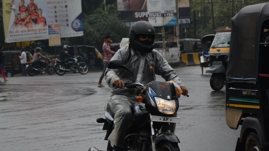 A man drives his bike in a raincoat amid the rains at Sakchi in Jamshedpur on Wednesday. 