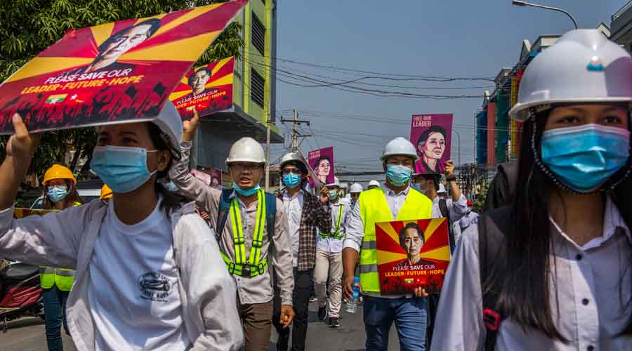People march along a street in Mandalay, Myanmar, Friday, Feb. 26, 2021, to protest against the military coup