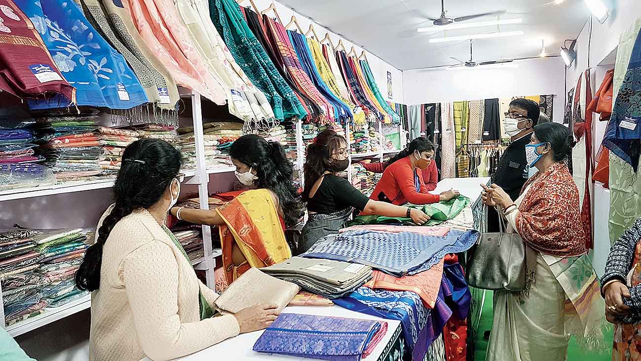 Customers check out various saris at the Tantuja stall at Central Park fairgrounds . 