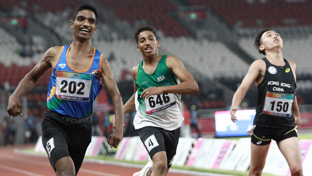 India's Narayan Thakur (L) celebrates after winning gold medal of the men's 100 metre T35 sprint of the 2018 Asian Para Games in Jakarta, Indonesia on October 9, 2018.