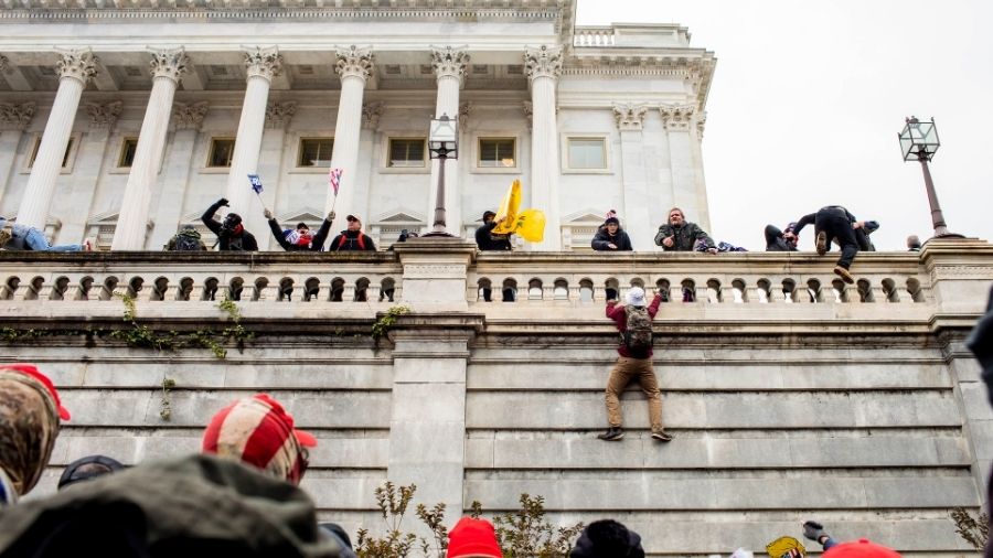 Protesters climb the Capitol to enter it, in Washington on Wednesday.