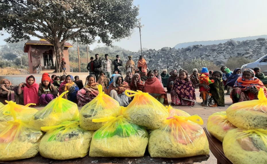 People from the economically weaker sections of the society sit with the food grans that were offered to them on the occasion of Makar Sankranti, at Katras, Dhanbad, on Thursday.