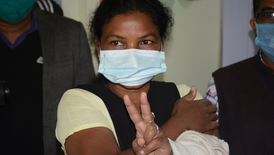 Alice Biswas Banra, the first health worker to receive the vaccine in Jamshedpur, shows the victory sign after receiving her shot at MGM Medical College in Dimna on Saturday. 