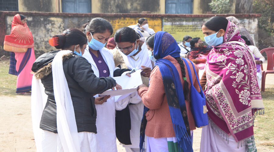 Health workers check the registration chart in Dhanbad.