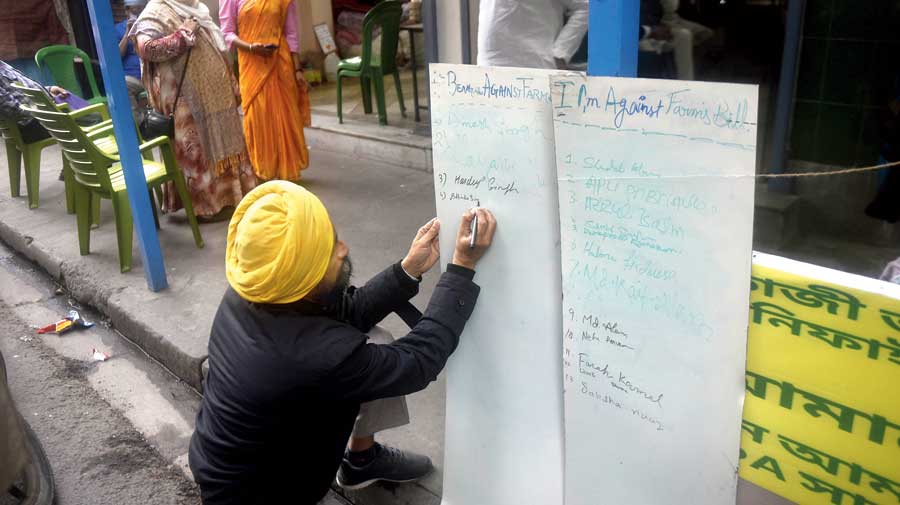 A protester writes the names of the people fasting on Monday at the Sarat Bose Road venue. A relay hunger  strike, led by women, is part of the demonstration.