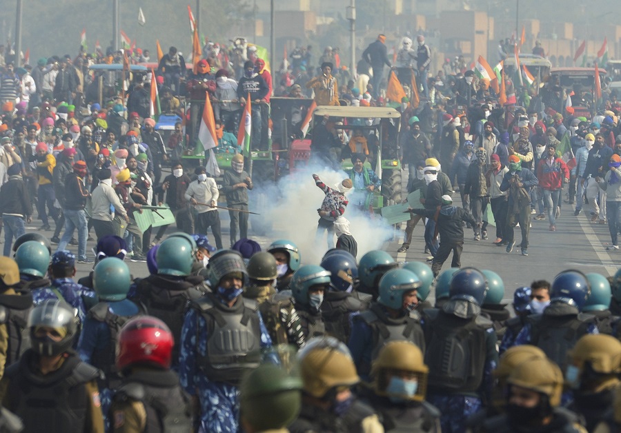 Police uses tear gas to disperse farmers attempting to break barricades at Ghazipur border during their Kisan Gantantra Parade, in New Delhi on Tuesday.