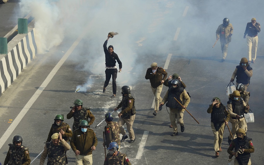 Police uses tear gas to disperse farmers attempting to break barricades at Ghazipur border 