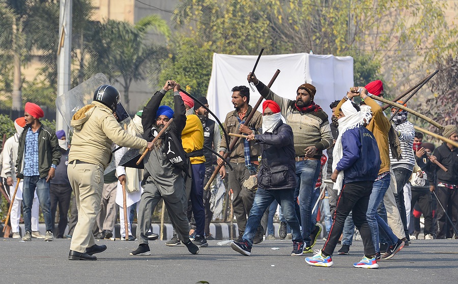 Protesting farmers clash with the police during their tractor march on Republic Day, in New Delhi on Tuesday.