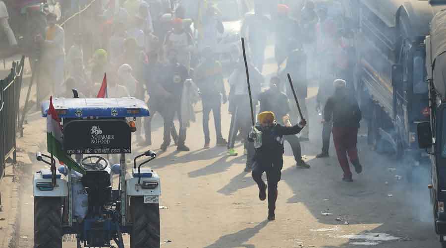 Security personnel use teargas shells to disperse farmers during clashes after their tractor rally turned violent