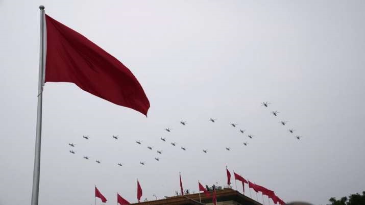 Helicopters fly over Chinese flags at Tiananmen Square in the formation of